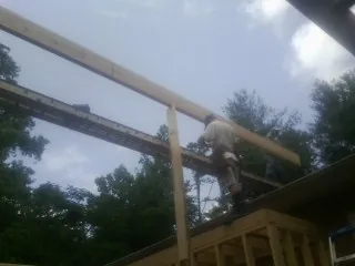 Carpenter setting a ridge beam over a new addition frame — Ice Dam Removal by Roofing Brothers in Lester Prairie