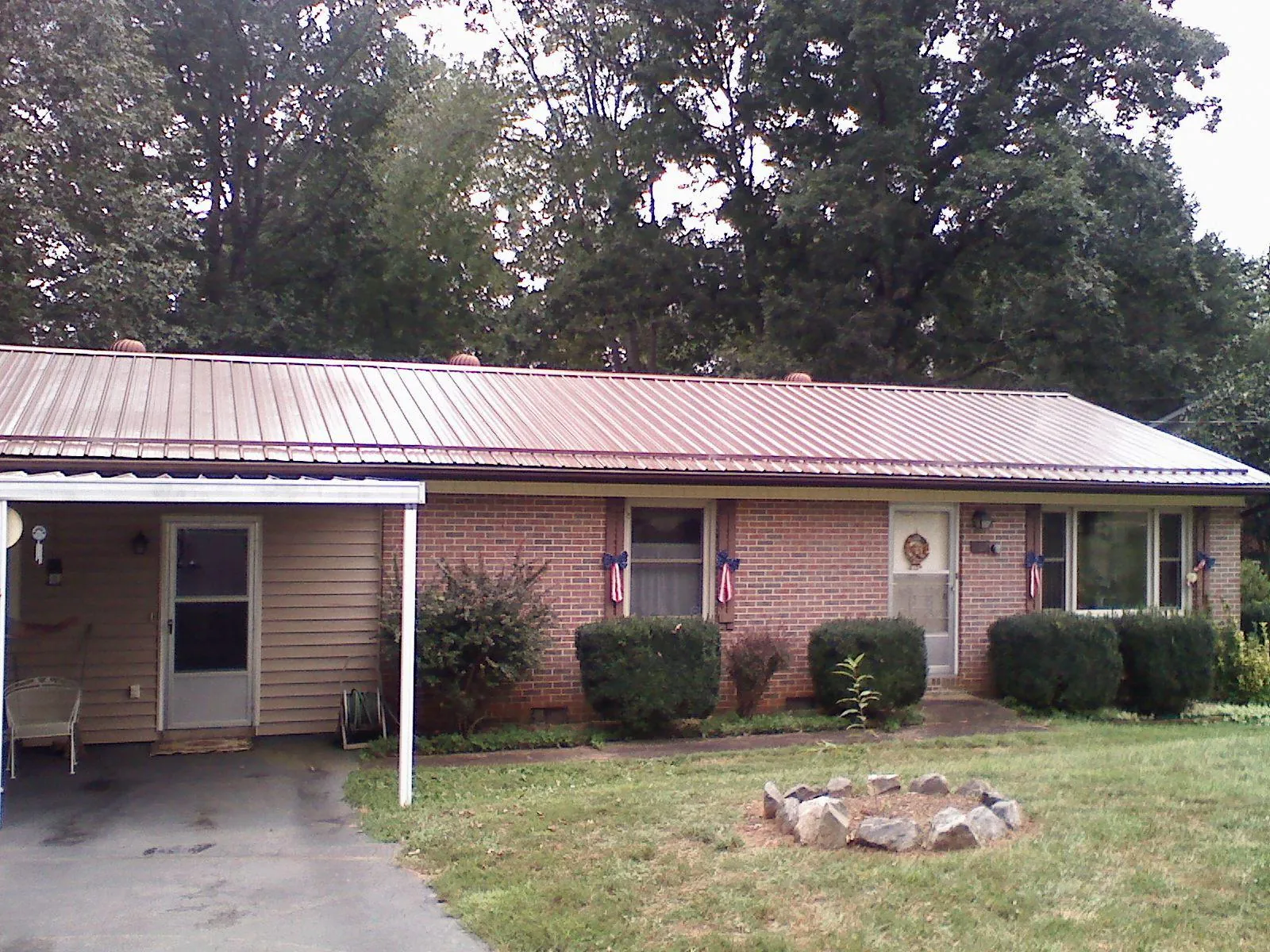 Bronze metal roof and carport on a brick ranch home — Roof Repair work by our crew in Lester Prairie